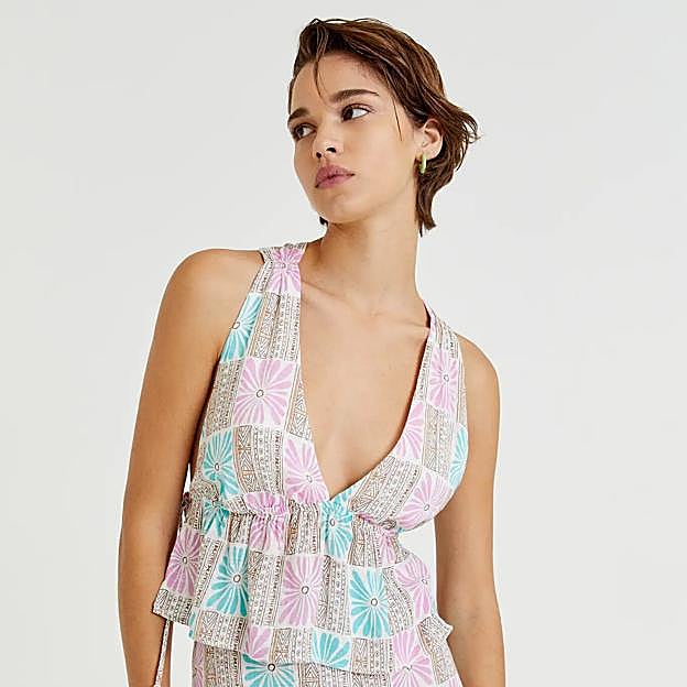 Este top con escote de pico cuenta con tirantes que se unen en la espalda con un nudo.