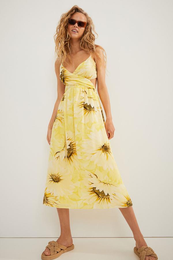 En color amarillo y con estampado de girasoles, este vestido midi con aberturas en los laterales y espalda descubierta cuenta con lazada amplia y tiene un precio de 29,99 euros. Es de H&M.