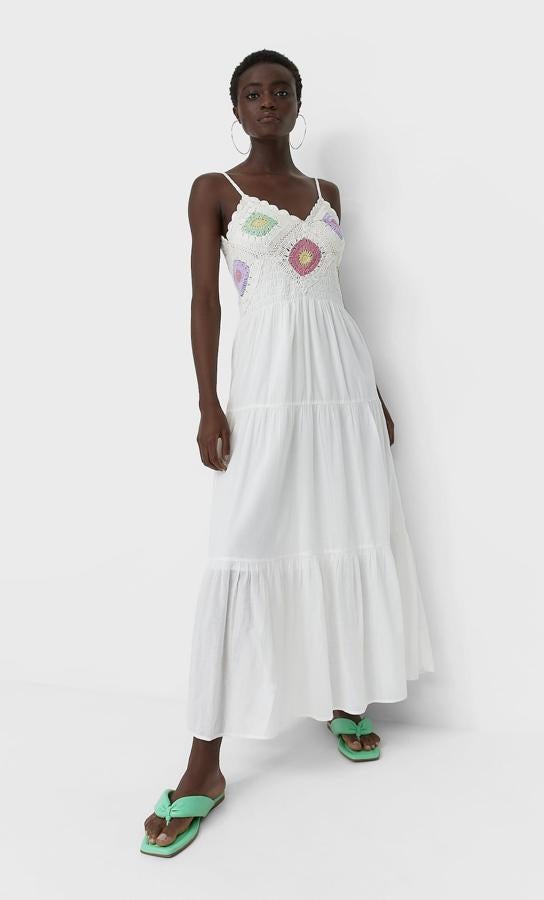 Este vestido largo de tirantes en color crudo con detalles de crochet de colores en el cuerpo cuenta con volantes en el bajo y tiene un precio de 39,99 euros.