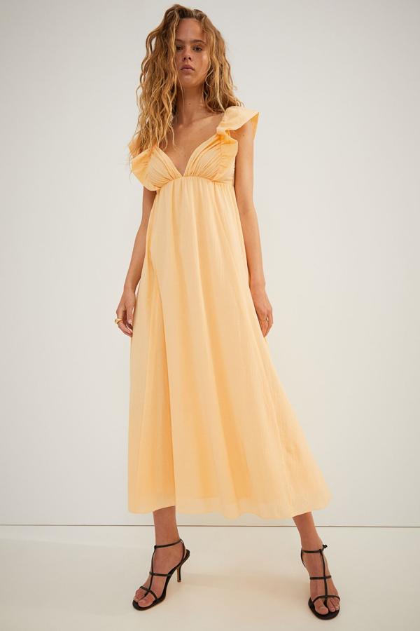 Disponible en color amarillo o albaricoque, este vestido midi con escote corazón y volantes en los hombros, cuenta con espalda descubierta y tiene un precio de 39,99 euros. Es de H&M.