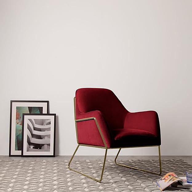 Butaca de terciopelo rojo con patas en dorado.