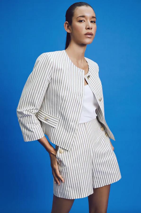 De cuello redondo y mangas largas con hombros marcados, esta blazer cropped en color crudo con estampado de rayas viene con falsos bolsillos delanteros con solapa y botón y cierre frontal con botones metálicos. Costaba 39,95 euros y ahora podemos comprarla por 25,99 euros.