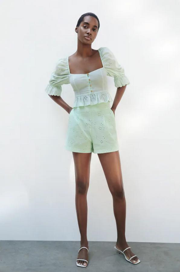 Diseño cropped con escote recto y mangas abullonadas para esta blusa con detalle de bordados perforados y acabados con volantes. Tiene elásticos tipo nido de abeja en la espalda y de 25,95 euros ha pasado a costar 17,99 euros. 