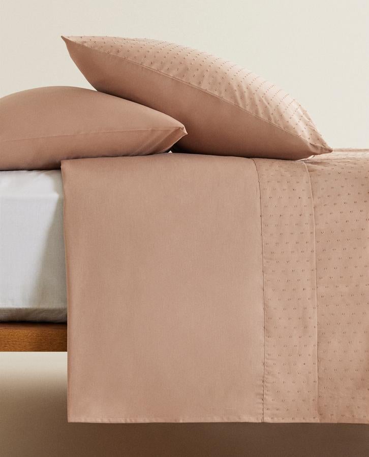 En color rosa, esta sábana encimera de algodón percal de 150 hilos cuenta con marco de plumeti y tiene un precio entre 12,99 y 29,99 euros dependiendo del tamaño.