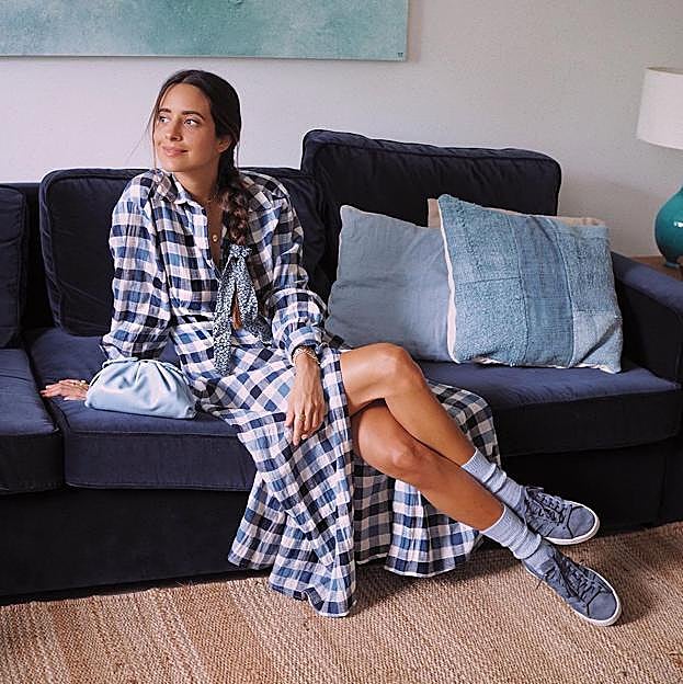 Salón con sofá de terciopelo y alfombra de yute.