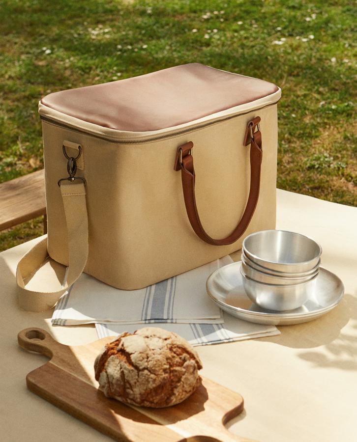 Con asa de cuero y tejido en algodón. Esta nevera portátil de Zara Home mantiene frescos los alimentos durante todo el día. Tiene un precio de 69,99 euros.