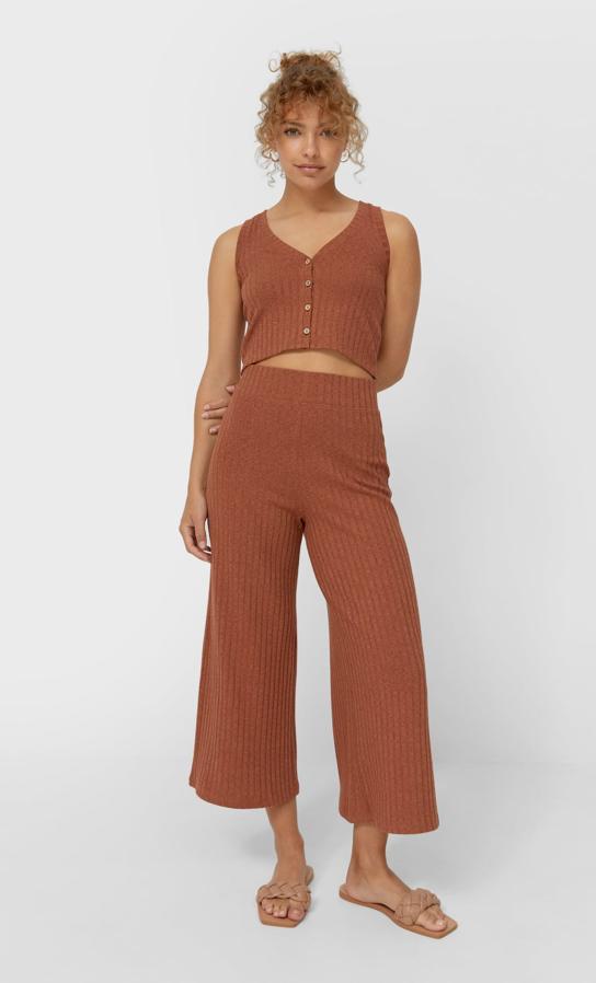 En punto fino y diseño básico, este pantalón culotte de diseño acanalado, con perneras amplias y cintura elástica es de Stradivarius y podemos encontrarlo en negro, piedra, caqui y marrón por 15,99 euros entre las tallas XS y XL.
