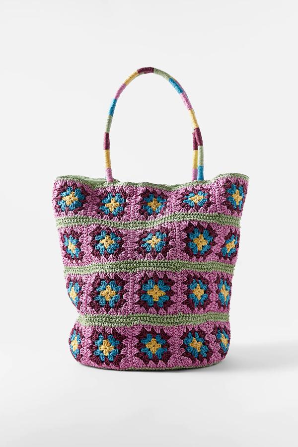 En tejido efecto crochet, este bolso tipo saca en color morado cuenta con asa de mano trenzada y cierre mediante imán. Tiene un precio de 29,95 euros.