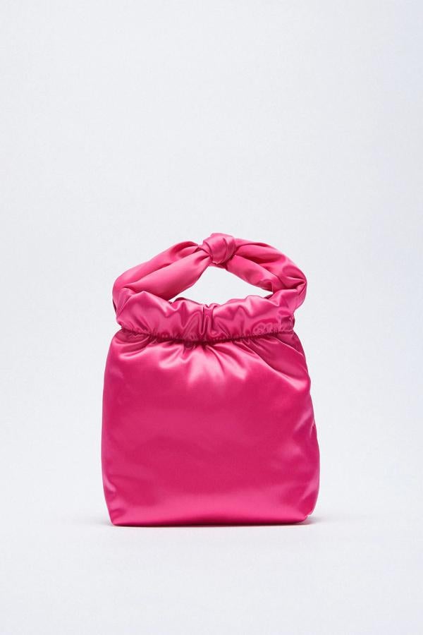 En color rosa fucsia, este bolso formato saca con cuerpo satinado cuenta con asa de mano del mismo tejido y asa de hombro con cadena. Tiene un precio de 19,95 euros.