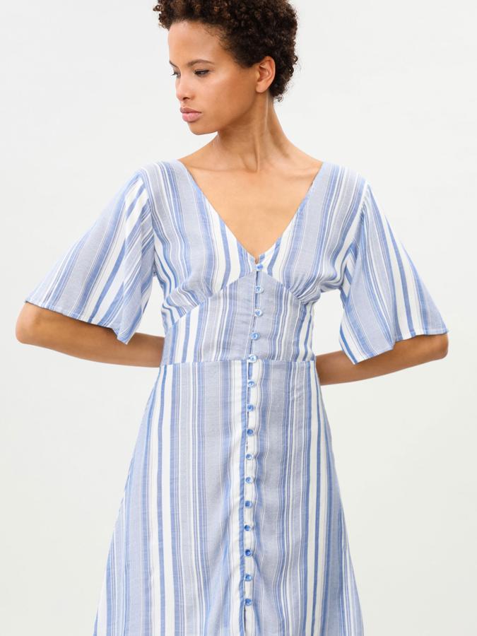 Este vestido corto con botones en la parte delantera y lazada en la trasera está confeccionado en un tejido ligero y fluido y tiene un precio de 9,99 euros (antes 17,99 euros).