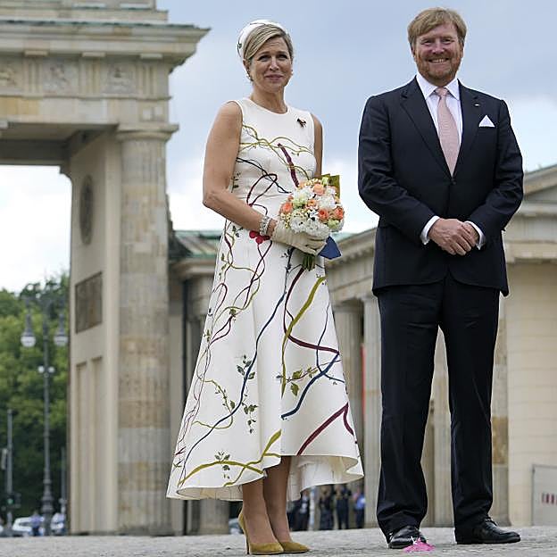 La reina Máxima de los Países Bajos junto a su marido con el primer modelo que lució en su viaje oficial a Alemania.