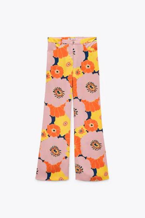 Pantalón de tiro alto, acampanado, con estampado floral 'maxi' en tonos azul, rosa, naranja y amarillo. Su precio está rebajado.