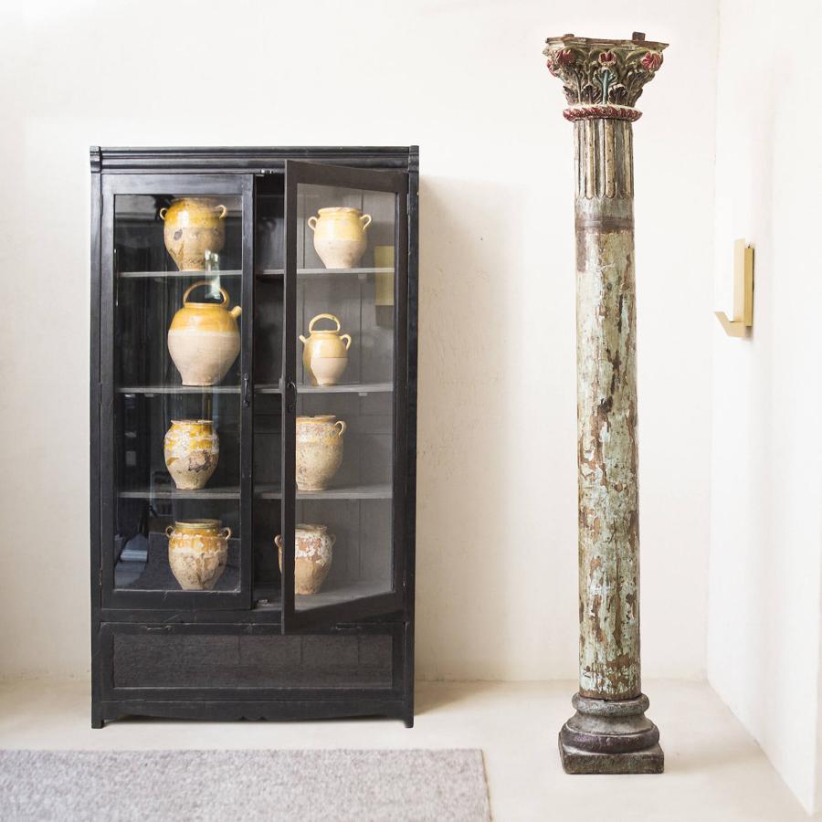 “Es preferible escoger pocas cosas pero bien pensadas a abarrotar el espacio. No hay que tener miedo al vacío, una pieza de arte contemporáneo o una antigüedad tienen una presencia imponente, no les robes protagonismo, solo conseguirás ensombrecerlas”. En la imagen, vitrina negra vintage y columna antigua, de Tristán Domecq Casa.