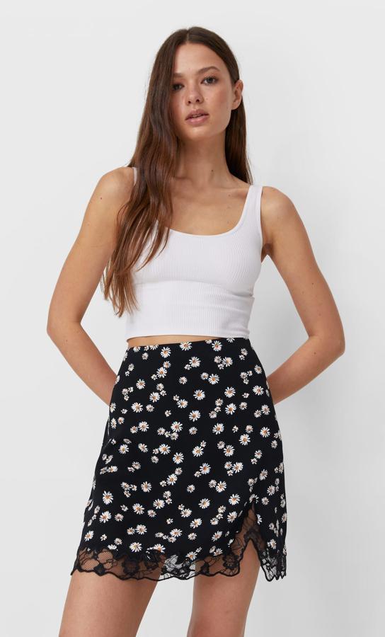 En color negro con pequeñas flores estampadas, esta falda mini de tiro alto y efecto satinado cuenta con abertura en el bajo y detalle de blonda. Ahora tiene un precio de 12,99 euros (antes 17,99 euros).