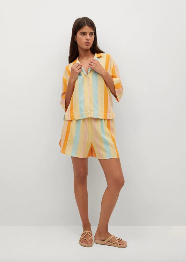 En amarillo pastel, con rayas naranjas y aguamarina, esta camisa que pertenece a la colección sostenible de la firma es de diseño recto y está confeccionada en tejido fluido. Con cuello de pico con solapa y mangas cortas, tiene el bajo asimétrico y cuesta 19,99 euros. Podemos encontrarla en las tallas S, M y XL.