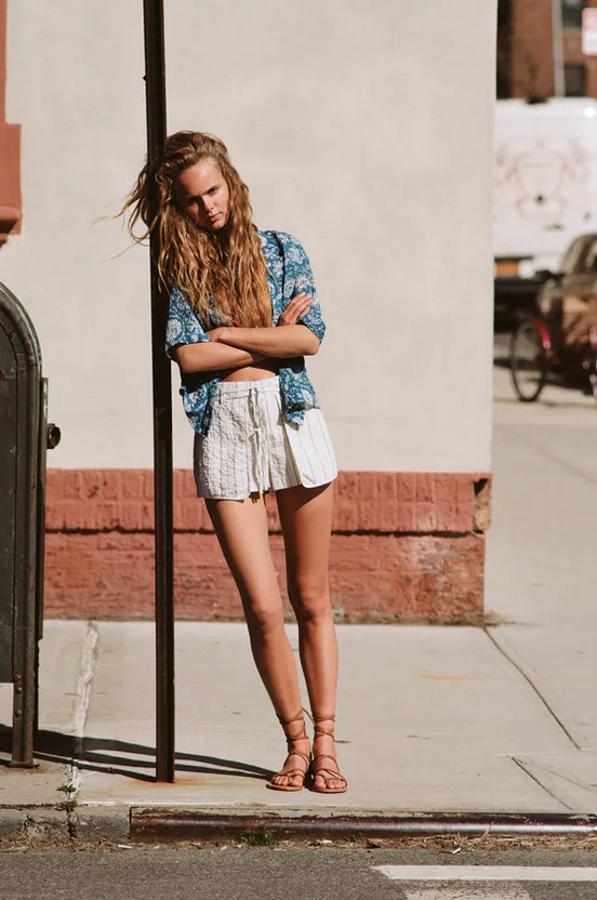 Estos shorts rústicos de Zara vienen con tiro alto, cintura elástica en la espalda y bolsillos laterales. Con cierre frontal con botones y lazada, en color crudo con estampado de rayas verticales en azul, han pasado de 22,95 euros a costar 9,99 euros. 