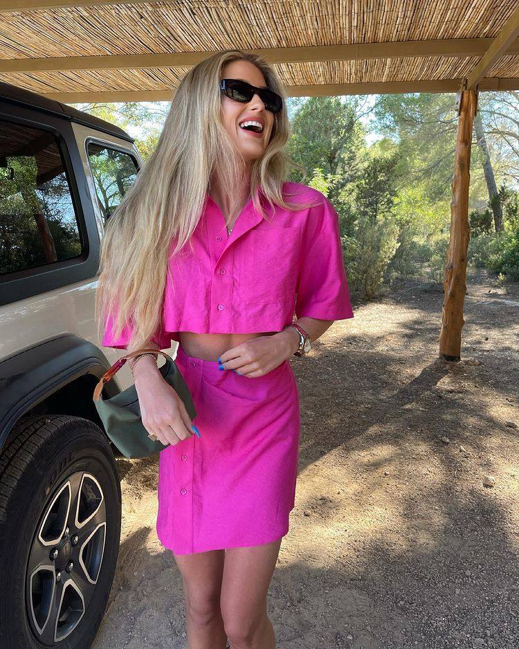 La 'influencer' lleva un dos piezas del color de la temporada: el rosa fucsia. Conjunta camisa de manga corta, que deja ver el abdomen, y mini falda abotonada a un lado, ambas prendas de tejido ligero.