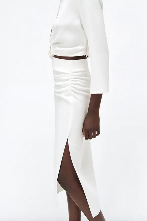 Diseño midi para esta falda blanca de tubo de Zara con detalle de pliegues en un lateral y bajo acabado en abertura por encima de la rodilla. Disponible entre las tallas XS y XXL, cuesta 29,95 euros. 