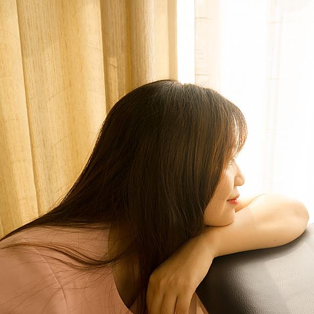 Mujer mirando desde una ventana