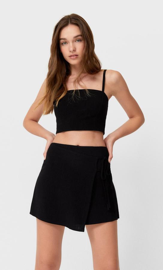 Diseño rústico con escote recto y tirantes finos para este top negro de Stradivarius que tiene un precio de 12,99 euros y está disponible entre las tallas XS y XL.