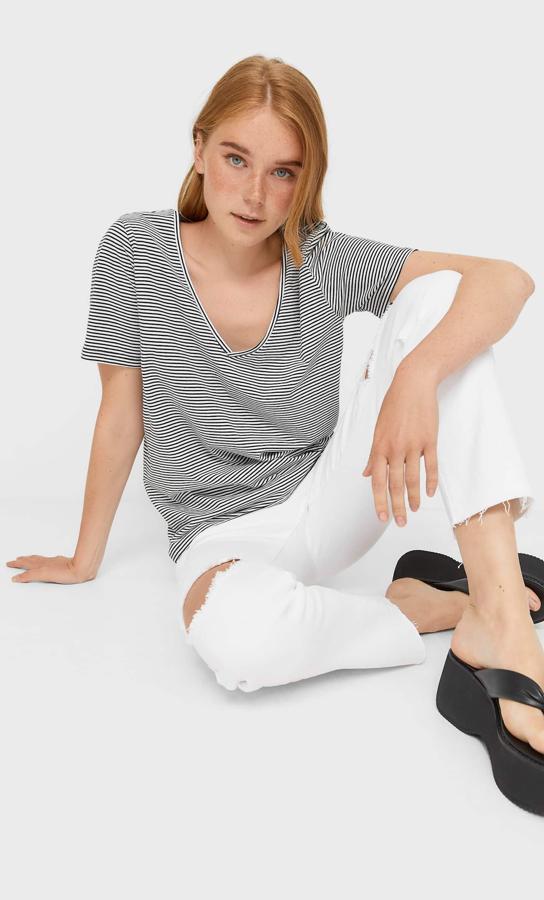 Con rayas negras y blancas, esta camiseta de manga corta de Stradivarius viene con escote de pico y podemos encontrarla entre las tallas XS y XL por 5,99 euros. 
