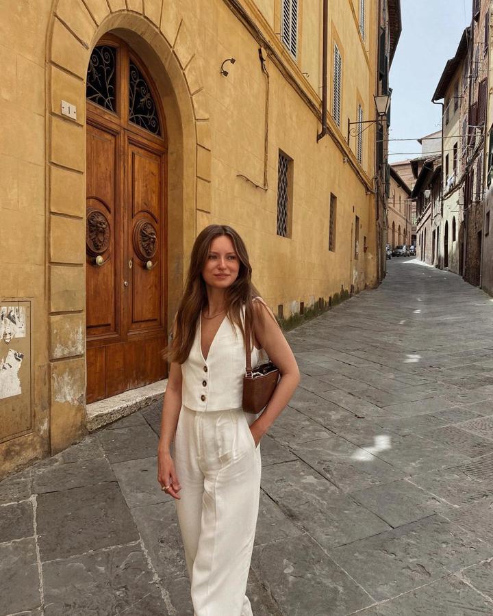 Los conjuntos están en tendencia. Este dos piezas de tejido ligero, compuesto por pantalón y chaleco abotonado, en tono neutro, es el último grito. Para ir fresquita y elegante. Termina con un bolso baguette noventero.