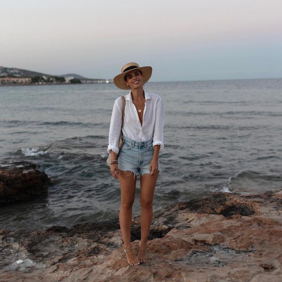 Camisa blanca + shorts vaqueros + sombrero de rafia