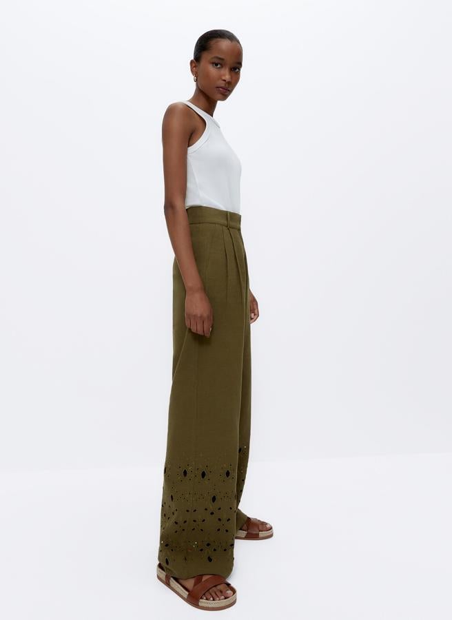 De lino en color verde caqui, este pantalón con bolsillos laterales y cinturón cuenta con detalle de bordados con motivos florales en el bajo. Ahora su precio es de 39,95 euros (antes 89 euros).