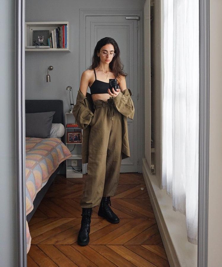 Aquí vemos un bralette básico negro, bajo un conjunto de camisa y pantalón anchos de tejido ligero, en color khaki. Como calzado, unas botas moteras.