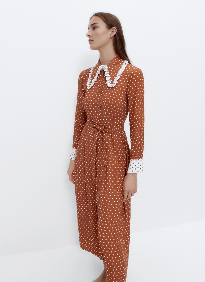 En color camel con lunares blancos, este vestido midi con cuello bobo con volantes cuenta con cinturón en el mismo tejido y tiene un precio de 59,95 euros (antes 119 euros).