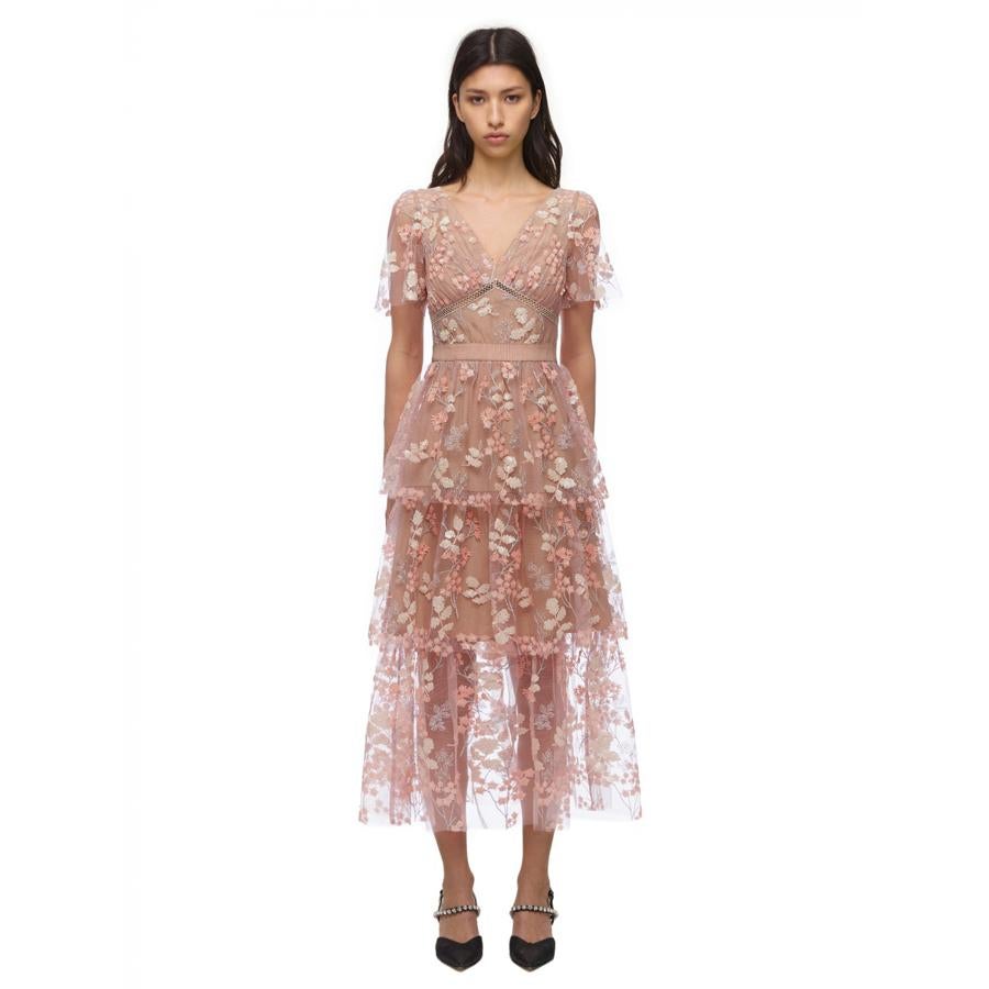 Vestido midi con falda de volantes, semi transparencias y bordados florares, en rosa nude.