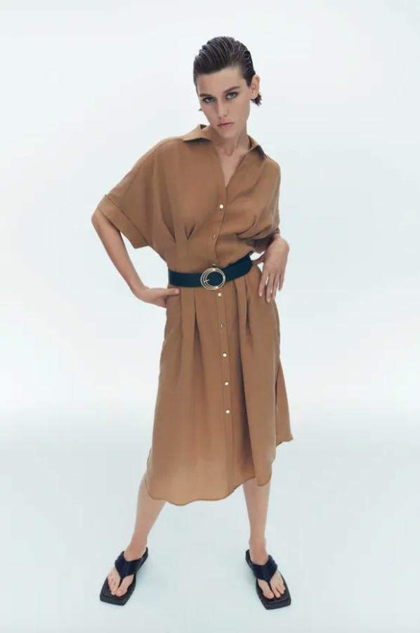 Con cuello solapa, escote de pico y mangas cortas acabadas en vuelta, este vestido camisero con detalle de pliegues en la cintura y cinturón combinado a contraste viene con cierre frontal de botones dorados y bajo con aberturas laterales y cuesta 39,95 euros. Podemos encontrarlo entre las tallas XS y XL. 