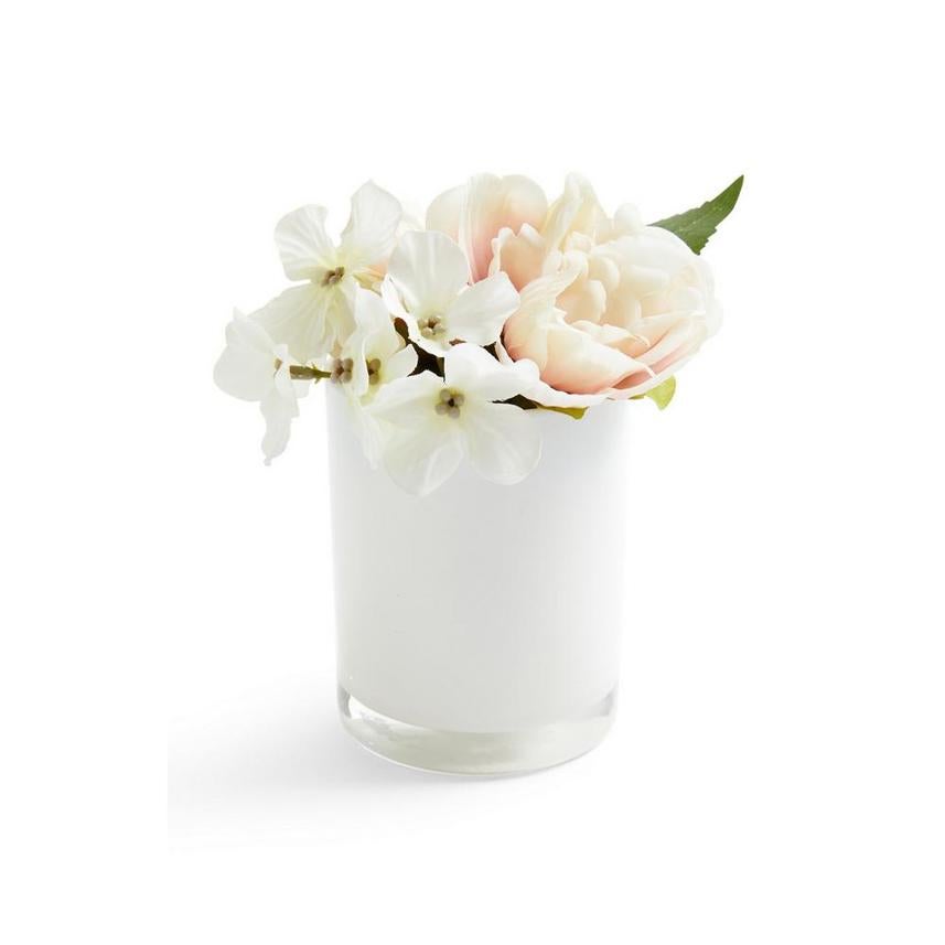 Macetero redondo en color blanco con flores artificiales. Cuesta 3 euros.