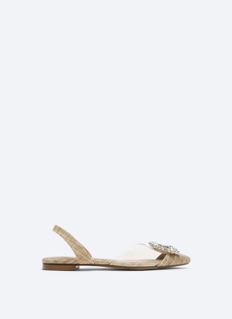 Sandalia plana de tela con pvc transparente y hebilla de strass, de Uterqüe (99 €).