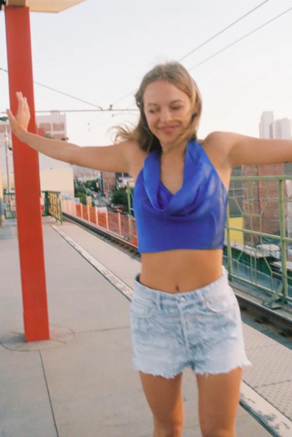 De escote fluido y tejido satinado, este top cropped en color azul viene con cierre con lazada en cuello y espalda y cuesta 17,95 euros. Podemos encontrarlo entre las tallas XS y XL. 