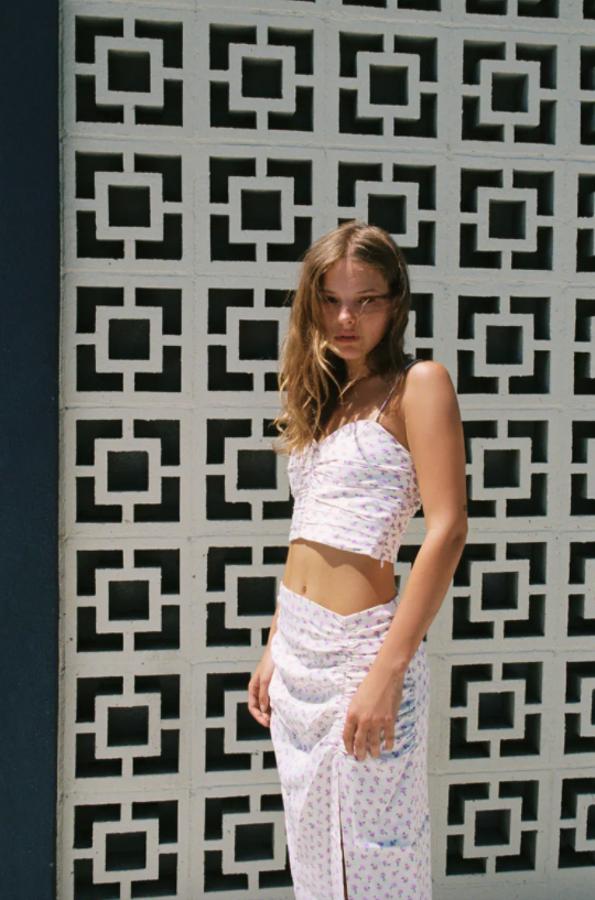 Diseño cropped con escote de pico y tirantes finos ajustables para este top de color crudo con estampado de flores que viene con detalle de frunces y elásticos en la espalda. Disponible entre las tallas XS y XL, cuesta 19,95 euros. 