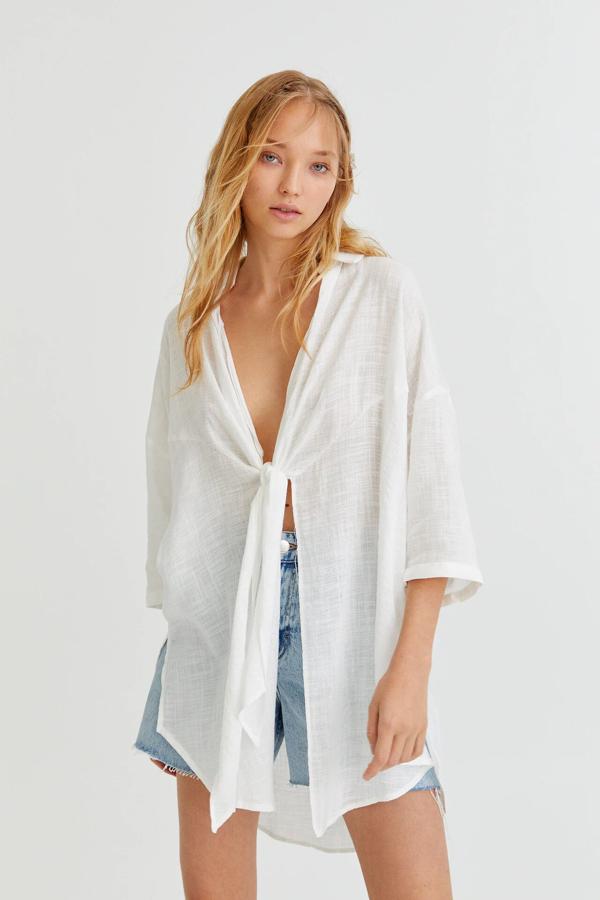 Esta camisa blanca oversize con nudo delantero y manga francesa tiene un precio de 25,99 euros.