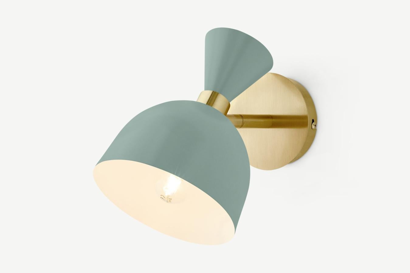 Lámpara de pared en verde salvia con detalles en dorado (29 euros).