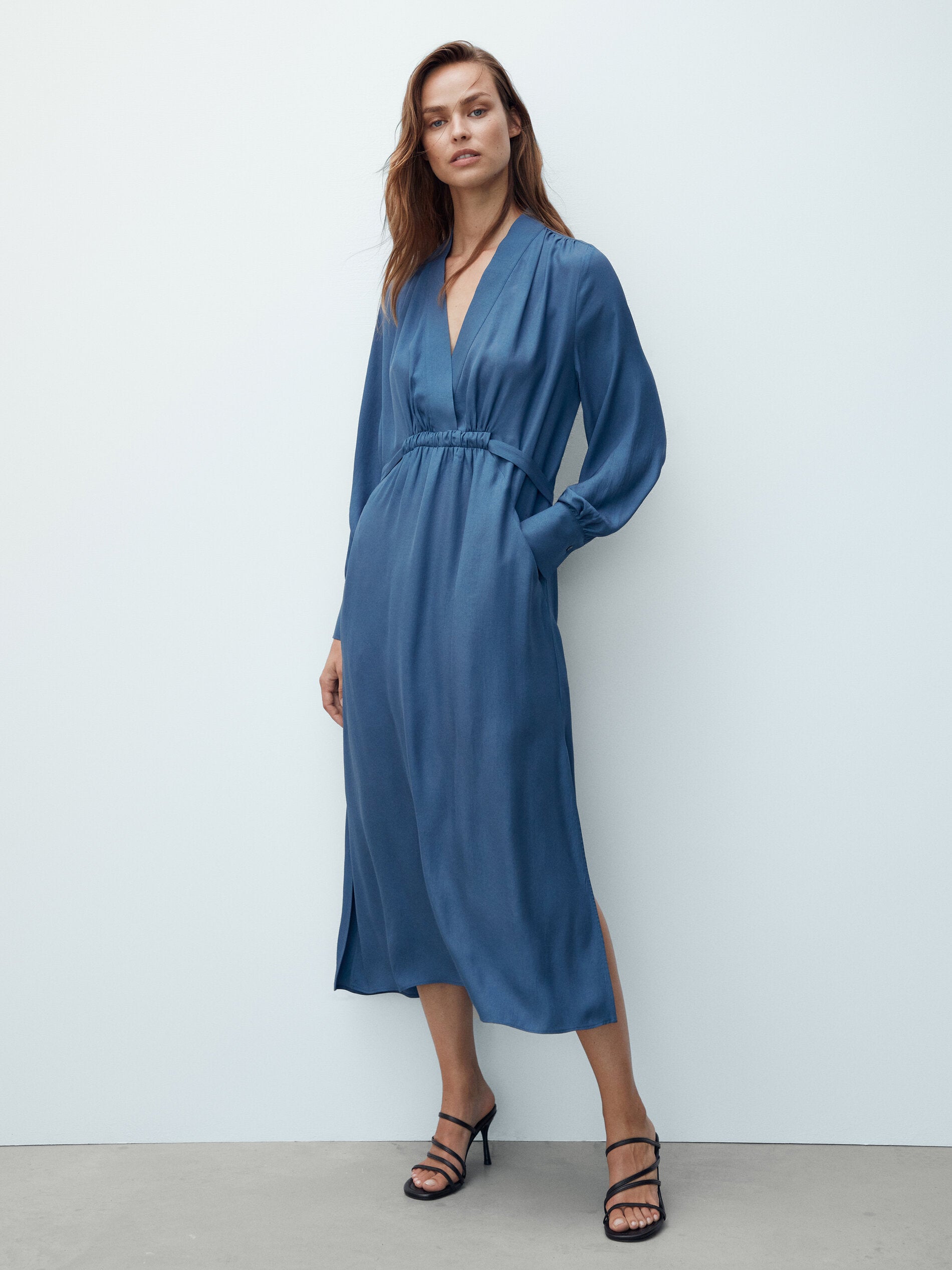 El vestido camisero evoluciona y toma como referencia los cortes fluidos de los años 70 para resultar en una prenda ligera, de largo midi y con manga larga. De escote cruzado y en un intenso color azulado, es perfecto para llevarlo solo mientras aún hace calor, pero también sienta de maravilla combinado con una cazadora de efecto cuero.