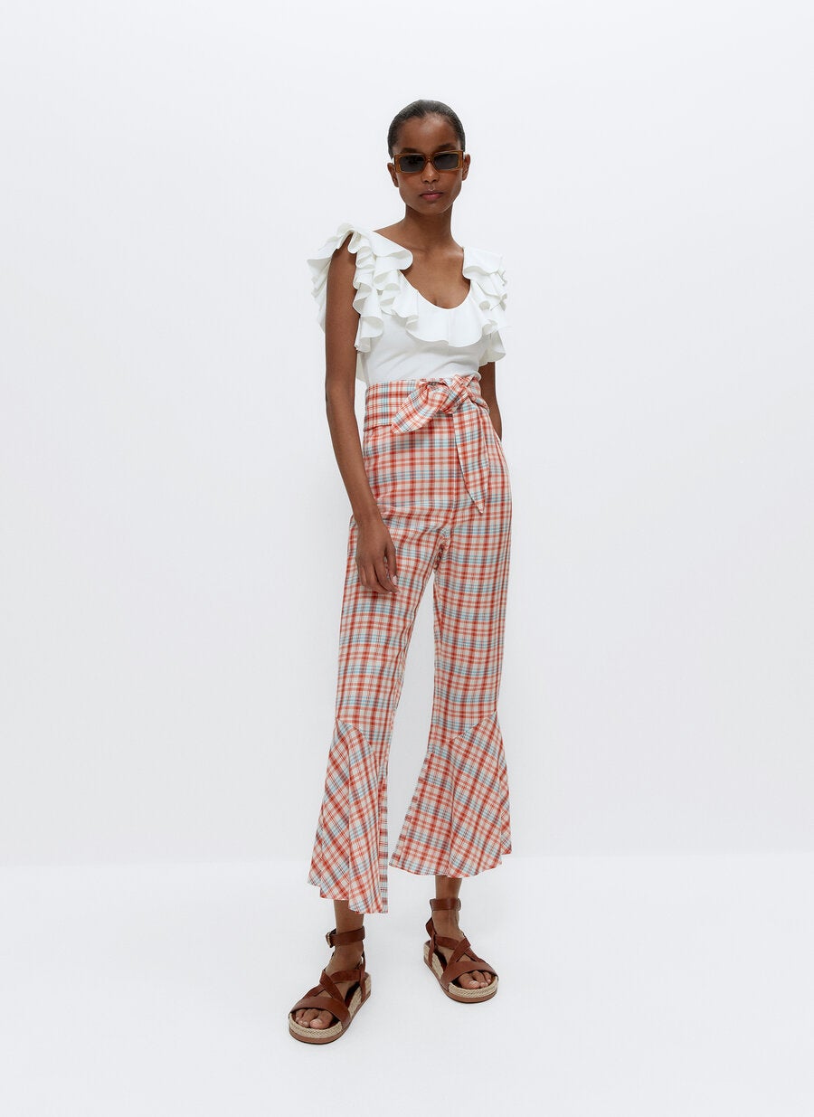 Pantalones de cuadros con volante en el bajo, cintura alta y cinturón anudado a juego, de las rebajas de Uterqüe (39,95 €).