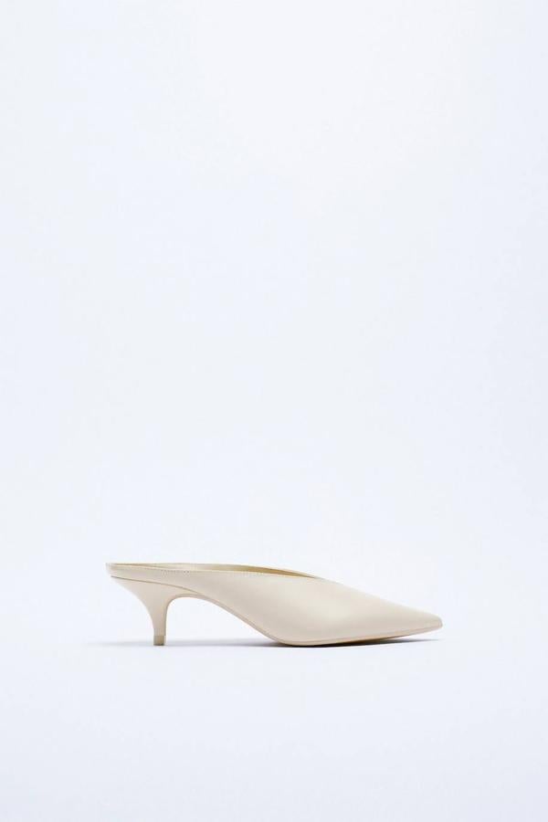 Zapato de piel destalonado con tacón bajo y escote en v, en tono blanco crudo.