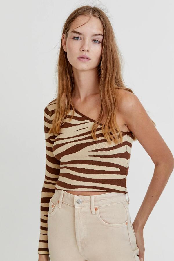 Este jersey asimétrico de punto con estampado animal print está disponible en marrón o en negro. Con una sola manga y silueta ajustada tiene un precio de 17,99 euros.