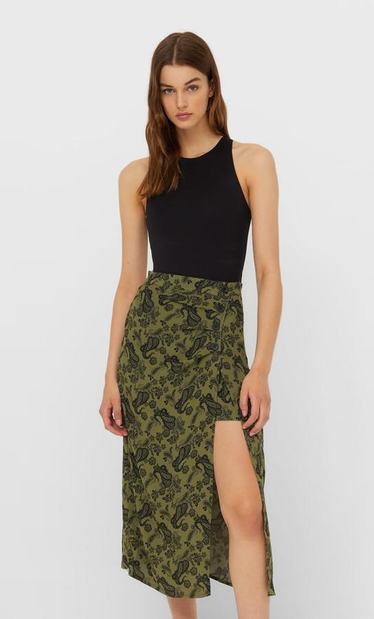 Diseño midi pareo para esta falda en verde caqui de Stradivarius con estampado paisley en negro. Con falsos botones y abertura en un lateral, podemos encontrarla entre las tallas 34 y 40 por 19,99 euros. 