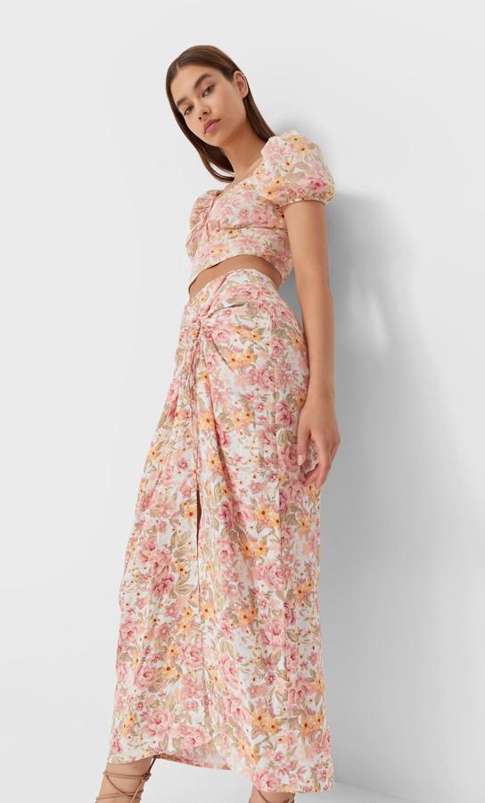 Esta preciosa falda de color blanco con estampado de flores en rosa y naranja es de Stradivarius, de tiro alto con nudo delantero y abertura lateral. Disponible entre las tallas 34 y 42, cuesta 19,99 euros. 