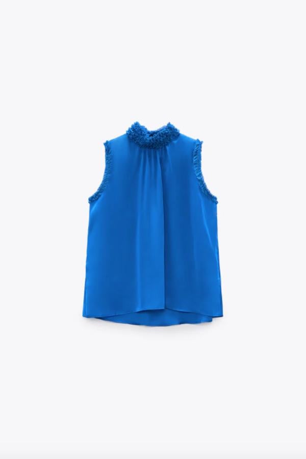 En tejido satinado, con detalle de acabados con volantes combinados en el cuello y las mangas, este top en azul cobalto tiene un precio de 19,95 euros y está disponible entre las tallas XS y XL. 