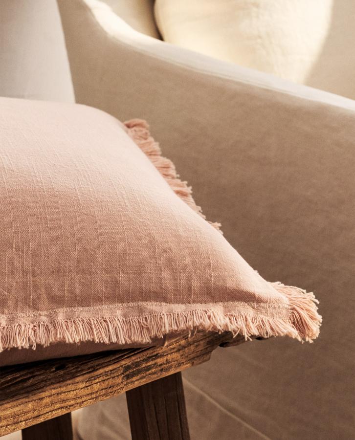 Con detalle de flecos en los extremos, esta funda de cojín en rosa empolvado mide 45x45 centímetros y tiene un precio rebajado de 5,99 euros.