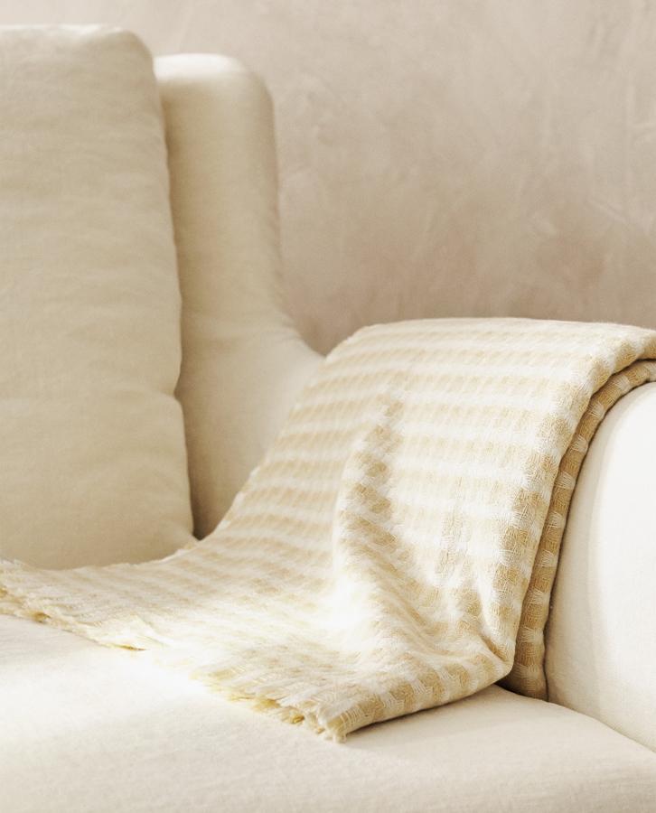 Confeccionada en tejido ligero y con estructura de cuadros, esta manta con acabado de flecos mide 140x190 centímetros y tiene un precio de 12,99 euros.