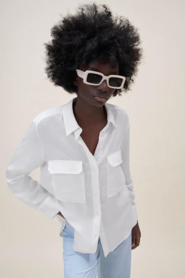 Con cuello de solapa y mangas largas acabadas en puño, esta camisa fluida de Zara con bolsillos de plastrón son solapa en la pechera y detalle de pliegue en la espalda viene con bajo asimétrico con aberturas laterales y cierre frontal con botones. Podemos comprarla por 29,95 euros. 