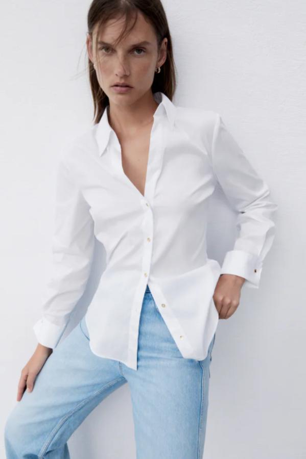 Diseño entallado para esta camisa blanca de Zara con cuello de solapa y cierre frontal de botones que cuesta 22,95 euros. 