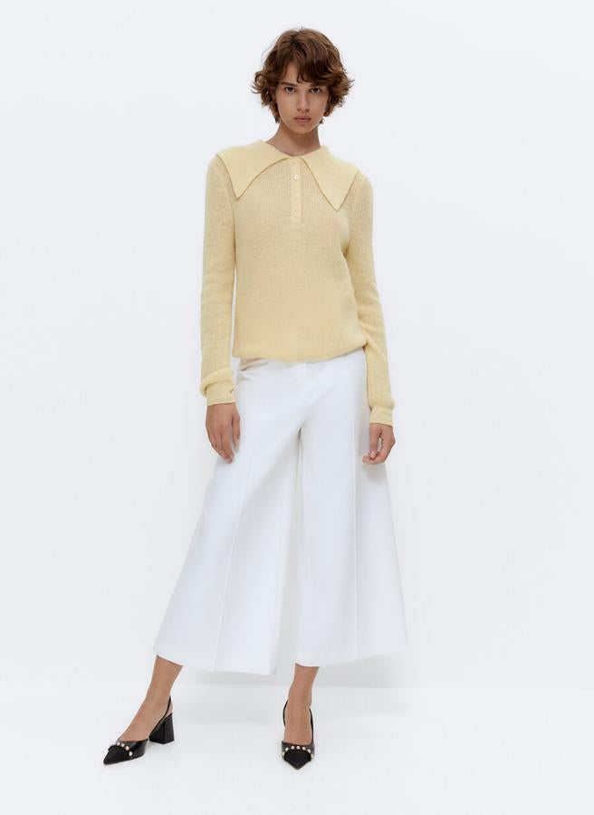 En color vainilla, confeccionado con mezcla de alpaca y cuello polo maxi, este precioso jersey de mangas largas y acabados en rib viene con escote de pico con cierre de botones a tono. Disponible en las tallas S y M, cuesta 89 euros.